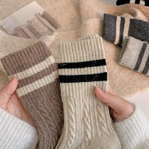 Detail of wool cable knit socks with vintage double stripes in warm autumn colors