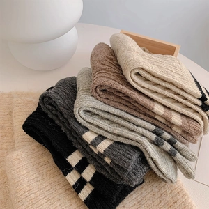 Detailed knit texture of thick wool socks in versatile earth tones with striped cuffs