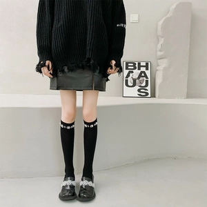 Detail of black over-the-knee socks featuring elegant 3D pearl flower embellishments