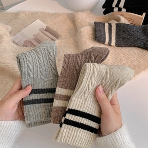 Detailed cable knit pattern on thick wool socks with classic collegiate stripes
