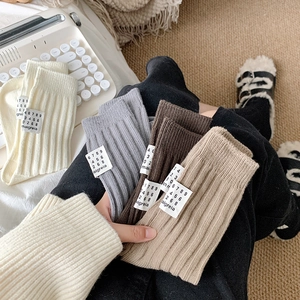 Close-up of ribbed knit crew socks with a minimalist fabric label in cozy earth tones