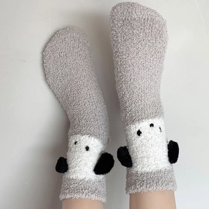 Détail des chaussettes en polaire corail épaisse avec un joli motif de pingouin