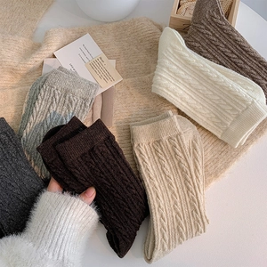 Detailed cable knit texture of thick wool socks in various warm earth tones