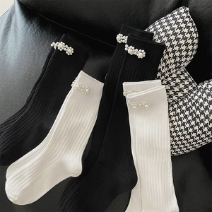 Detail of black and white calf socks with ribbed texture and elegant pearl flower accents