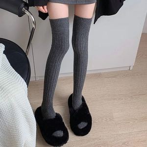 Detailed texture of gray ribbed wool over-knee socks with thick warm knit finish
