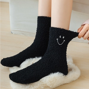 Women's black fuzzy coral fleece socks with cute smiley face embroidery for winter warmth