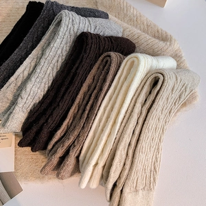 Close-up of cable knit texture on thick winter socks in various neutral colors