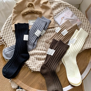 Close-up of ribbed cotton crew socks in neutral tones with numeric label detail