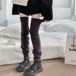 Thick knit over-knee leg warmers in dark grey paired with stylish black loafers