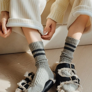 Close-up of thick grey cable knit wool socks with black stripes for autumn winter wear