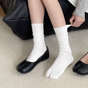 Japanese minimalist white ribbed tabi socks paired with black textured leather shoes