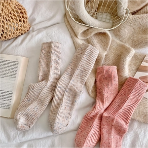 Detailed texture of thick ribbed knit wool socks with colorful speckled patterns