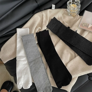 Detail view of cotton Tabi socks in white, grey, and black with ribbed vertical texture