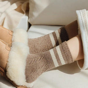 Close-up of thick brown wool socks with white stripes and detailed cable knit texture