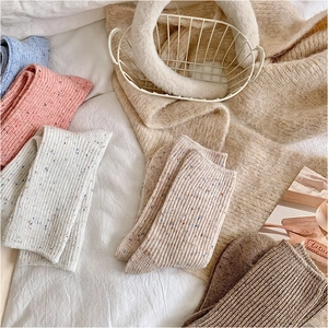Close-up of thick speckled wool socks in pastel colors with warm knit texture