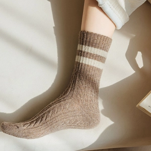 Close-up of thick brown wool socks with ivory stripes and ribbed cable knit texture
