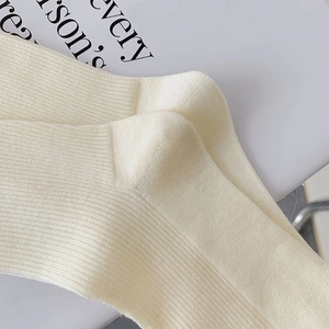 Dettaglio macro della calza in maglia a coste bianco crema con tallone rinforzato