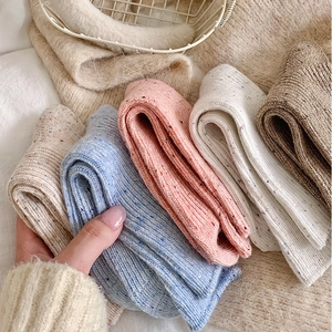 Close-up of colorful flecked wool socks in various colors with thick knitted texture