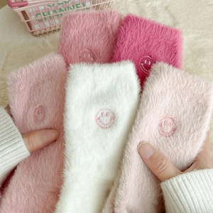 Dettaglio di morbide calze in pile di visone con ricamo smiley e calda trama in peluche