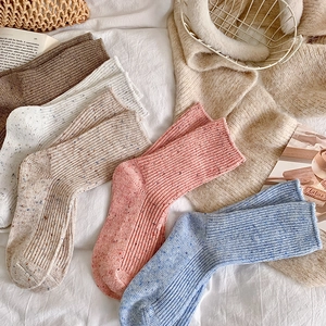 Detailed texture of thick wool knit crew socks with colorful flecked dot yarn pattern