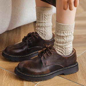 Detail of cable knit wool socks paired with vintage brown leather platform shoes