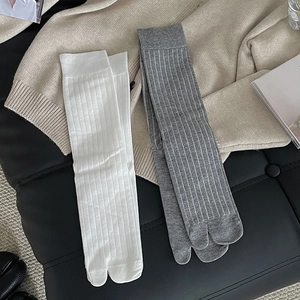 Close-up of ribbed texture and tabi toe design on white and grey crew socks