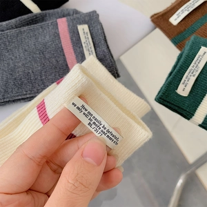 Dettaglio calze a righe che mostra la trama a maglia e l'etichetta minimalista