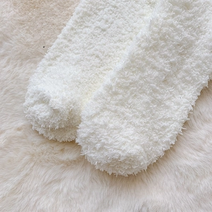 Close-up of thick white coral fleece socks featuring a soft plush texture for winter warmth
