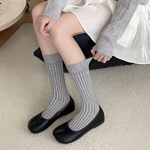 Japanese minimalist grey striped two-finger socks paired with black Tabi split-toe shoes