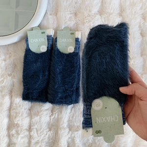 Detailed view of three pairs of thick navy blue plush thermal socks with knit cuffs