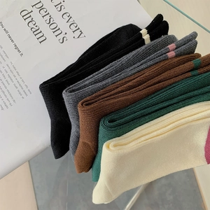 Dettaglio di cinque calze a coste colorate con motivo a righe su sfondo rivista