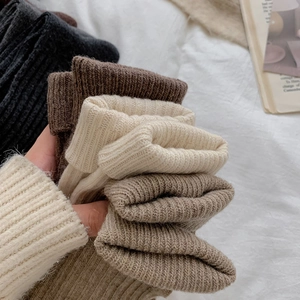 Close-up of thick knitted wool socks with vertical stripes in earthy neutral tones