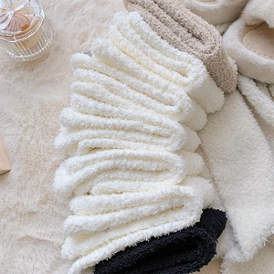 Macro view of thick coral fleece socks in cream and black with soft plush texture