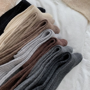 Detail of multi-color thick knit over-knee socks with vertical striped texture and warm wool