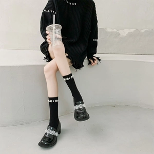Detail of black patent leather loafers with silver rhinestone band and pearl socks