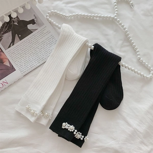 Close-up of ribbed knit socks featuring elegant handmade white pearl cluster embellishments