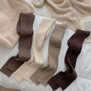 Close-up of four colors of thick ribbed knit over-the-knee socks for winter warmth