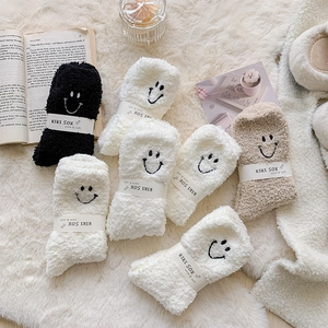 Detailed view of warm coral fleece socks with cute smiley face embroidery in various colors