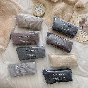 Detailed view of knitted vertical stripe socks in various colors with zipper packaging