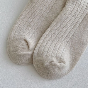 Close-up of thick ribbed knit wool socks in oatmeal beige showing soft texture and weave