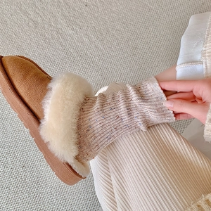 Brown suede winter slippers with plush faux fur trim and cozy wool knit socks
