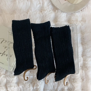 Detailed macro view of black ribbed knit socks texture and vertical stripes on acrylic stand