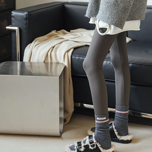 Dettaglio di calze in cashmere grigio scuro a righe e sandali neri foderati in pelliccia