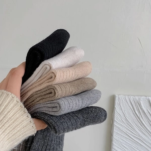 Close-up of ribbed knit wool socks in neutral colors showcasing thick soft texture