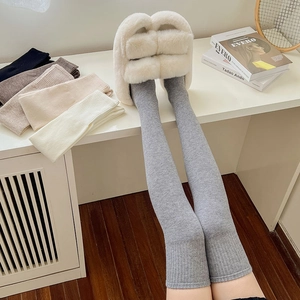 Close-up of over-the-knee wool socks with vertical ribbed knit texture in grey