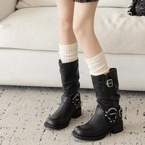 Détails de bottes mi-mollet en cuir noir avec boucles en métal et jambières tricotées