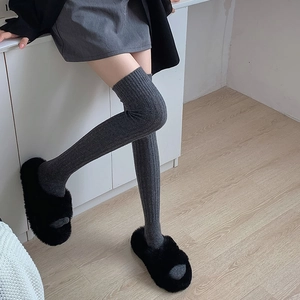 Deep grey knit over-the-knee socks with ribbed texture and black fuzzy plush slippers