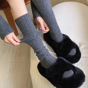 Detail of grey ribbed wool socks showing fabric elasticity and soft knit texture