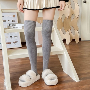 Detailed texture of gray over-the-knee wool socks with elastic ribbed cuffs for women