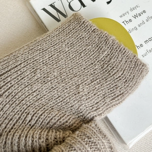 Gros plan sur la texture en maille épaisse des jambières kaki pour l'automne-hiver